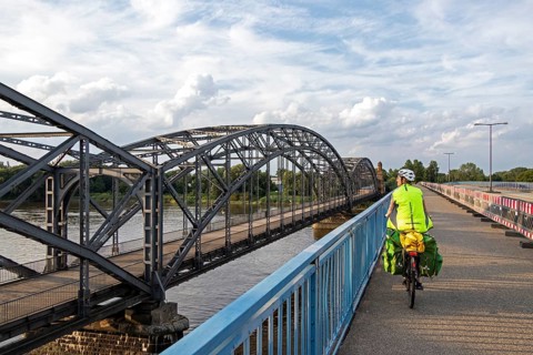Woman riding her bicycle over bridge next to the Alte Harbruecker Elbbruecke