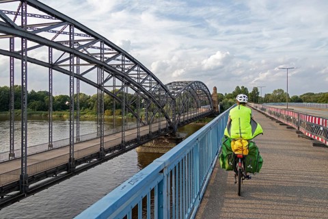 Woman riding her bicycle over bridge next to the Alte Harbruecker Elbbruecke