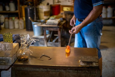 Working hot glass in the workshop of a glassblower