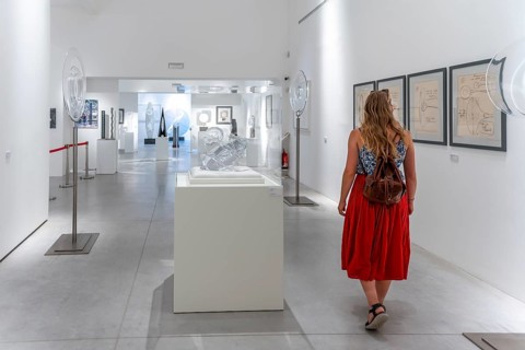 Young woman in the glass museum looking at hand-blown glass