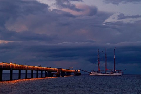 Evening atmosphere jetty with three-master sailing boat