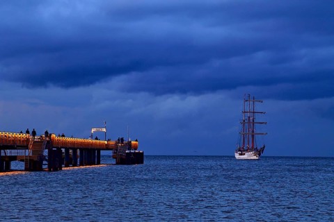 Evening atmosphere jetty with three-master sailing boat