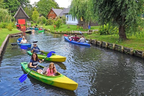 Tourists paddle through the village of Lehde