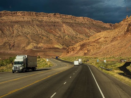 Truck on highway towards Arches Scenic Drive and Arches National Park