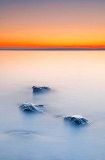 View from Arbon over Lake Constance at sunrise with stones in the foreground