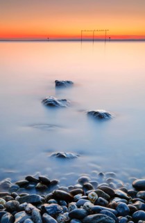 View from Arbon over Lake Constance at sunrise with stones in the foreground
