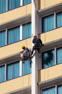 Two facade climbers hanging from a rope