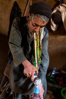 Sufi man preparing his marihuana pipe