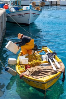 Fishermen on a small rowing boat in the harbour of Livadia on the island of Tilos