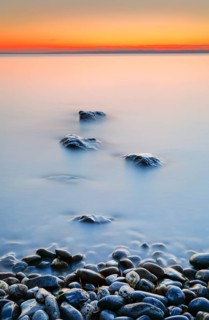 View from Arbon over Lake Constance at sunrise with stones in the foreground