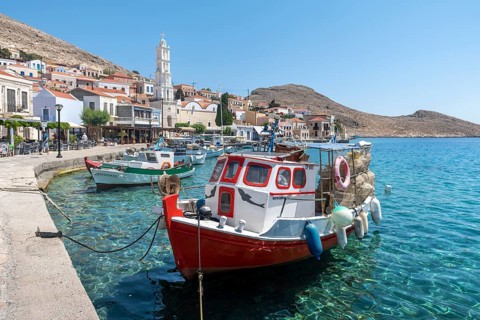 Fishing boats in the harbour of Halki with turquoise water