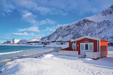 Red cottage in winter landscape