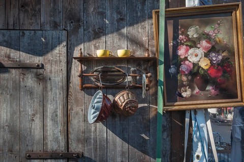 Paintings and bric-a-brac on old wooden wall