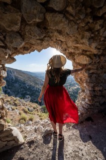 Young woman looking through hole in castle wall