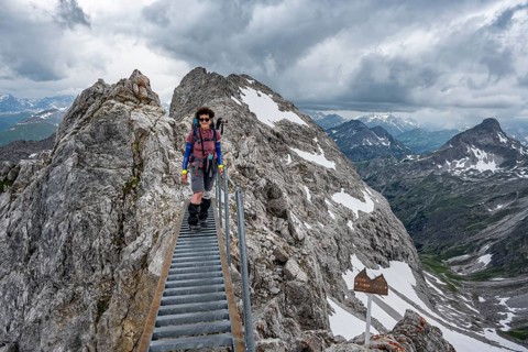 Hiker on a metal bridge on a rock
