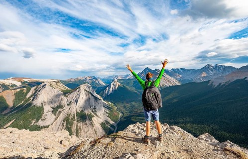 Hiker stretches his arms in the air