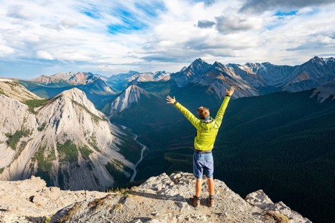 Hiker stretches his arms in the air