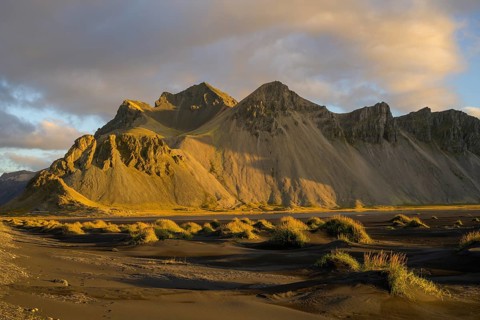 Dune landscape in front of mountain range in the morning light