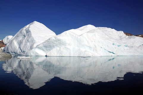 Iceberg reflected in a fjord