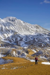 Woman in front of snowy mountains Fannborg and Snaekollur in the hot spring area Hveradalir