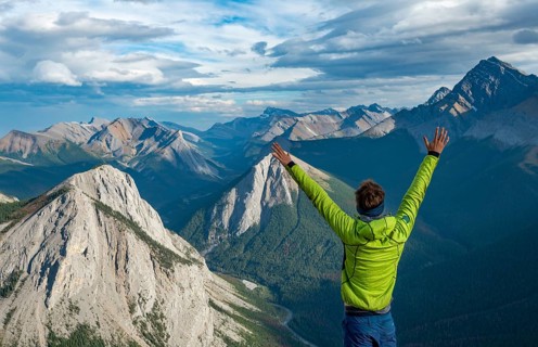 Hiker stretches arms in the air