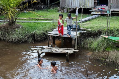 Children in the jungle village playing in the river