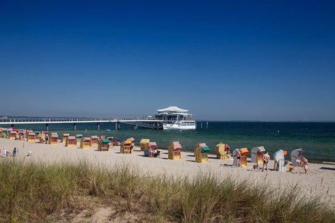 Beach chairs at Timmendorfer Strand with Seeschloesschenbruecke and Japanese teahouse
