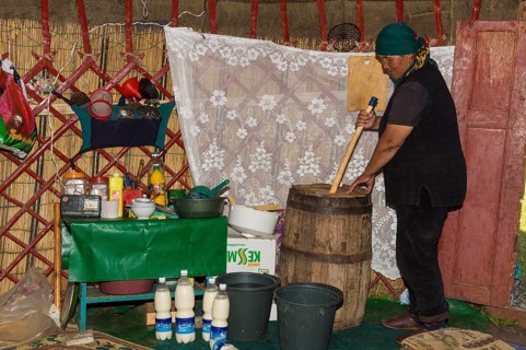 Kyrgyz woman mixing kumis during the fermentation process