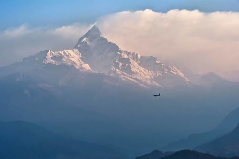 Small plane flies to sacred peak Machhapuchhare Fishtail Mountain