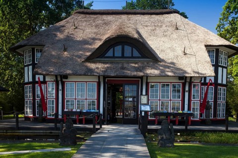Thatched roof house Mikado Garden with Buddha rope