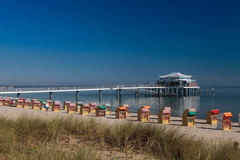 Beach chairs at Timmendorfer Strand with Seeschloesschenbruecke and Japanese teahouse