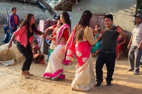 People of the Tharu ethnic group dance and laugh during a wedding