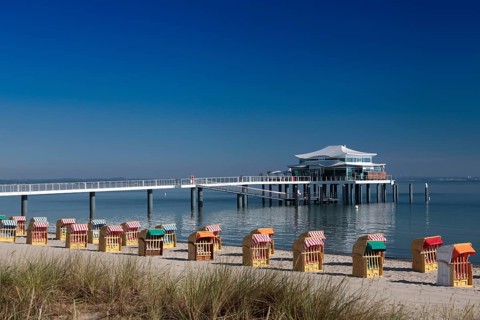 Beach chairs at Timmendorfer Strand with Seeschloesschenbruecke and Japanese teahouse