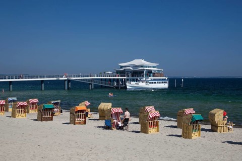 Beach chairs at Timmendorfer Strand with Seeschloesschenbruecke and Japanese teahouse