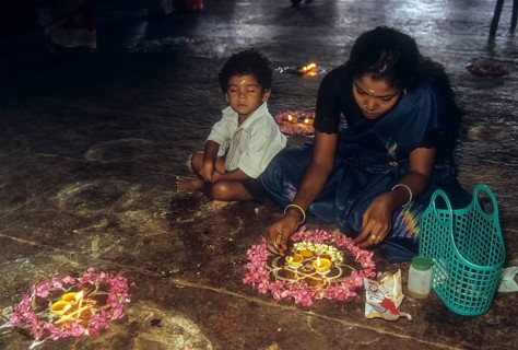 A woman lighting the oil lamp at a temple in Tamil Nadu