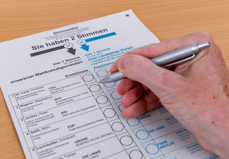 Hand with biros over ballot paper for the election of members of the German Bundestag on 26.09.2021
