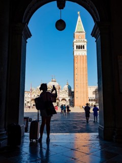 Silhouette of a tourist taking pictures with her mobile phone