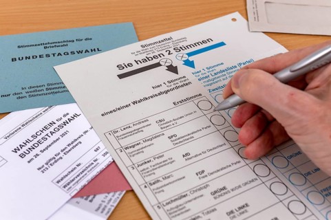 Hand with biros over ballot paper for the election of members of the German Bundestag on 26.09.2021