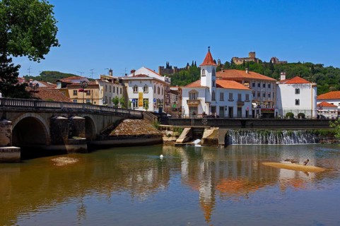 Renaissance bridge of Velha over the river Nabao and Templar Castle of Christ in the background