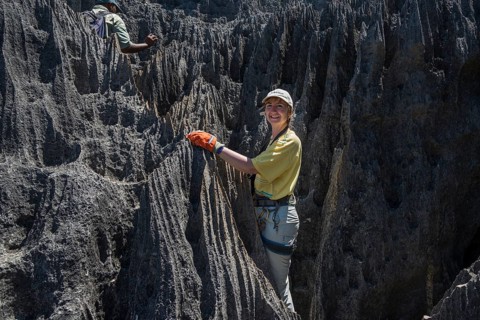 Woman climbing through rock needles of karst landscape