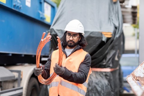 Technician with beard and helmet working in a recycling yard
