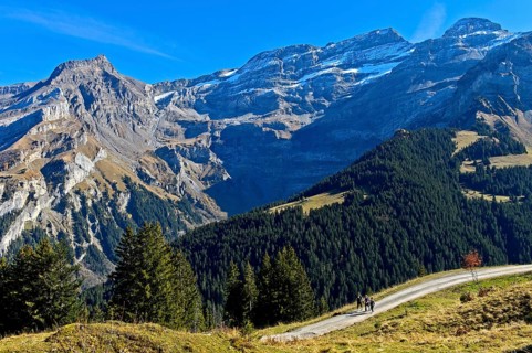 Hikers in front of the mountain range Les Diablerets near the village Les Diablerets with the peak Scex Rouge