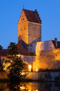 Illuminated Rothenburg Gate with city wall at the city pond