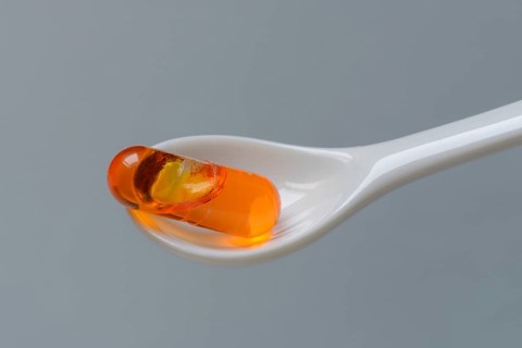 Capsule with omega-3 fatty acids in spoon