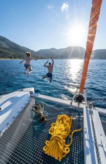 Young woman and young man jumping into the water