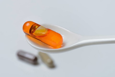 Capsule with omega-3 fatty acids in spoon