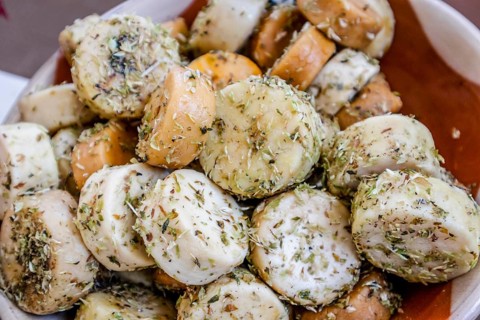Fresh small goat cheese with oregano sold on the market in Portugal