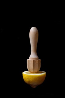 Lemon and lemon squeezer against a black background