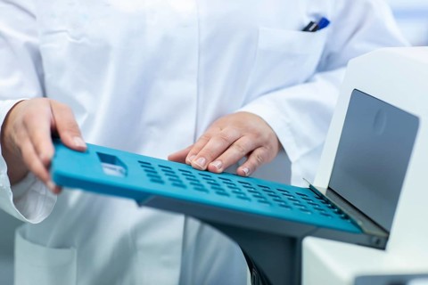 Young laboratory assistant with sample working in a laboratory with laboratory equipment
