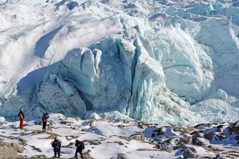 People in front of crevasses and ice front of a glacier